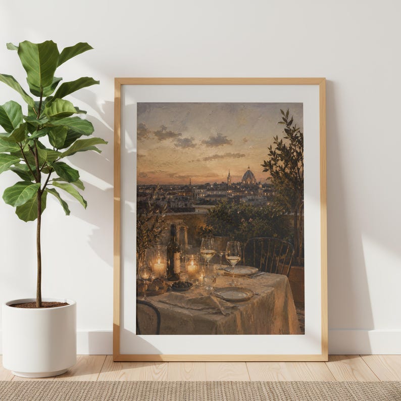 Pode incluir: Uma impress&atilde;o de arte de parede emoldurada retratando uma vista do p&ocirc;r do sol de um horizonte da cidade com uma c&uacute;pula, apresentando uma mesa posta para dois em um terra&ccedil;o com toalha branca, ta&ccedil;as de vinho, uma garrafa e velas acesas.