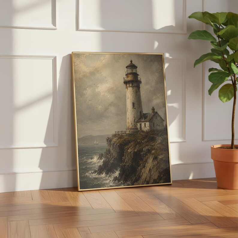 May include: A framed vertical wall art print depicting a lighthouse perched on a dark, rocky cliffside overlooking a turbulent ocean under a cloudy, overcast sky. The scene features muted tones of grey, brown, and white with a small sailboat.