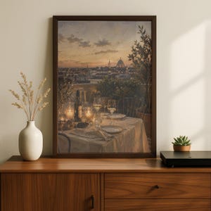 Pode incluir: Uma impress&atilde;o de arte emoldurada que retrata uma vista ao p&ocirc;r do sol de um horizonte urbano com uma c&uacute;pula, apresentando uma mesa de terra&ccedil;o posta com ta&ccedil;as de vinho, uma garrafa e velas acesas. A obra est&aacute; num aparador de madeira ao lado de um vaso.
