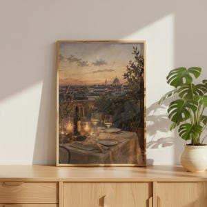 Pode incluir: Uma impress&atilde;o de arte de parede emoldurada retratando uma vista do p&ocirc;r do sol sobre o horizonte de uma cidade com uma c&uacute;pula, apresentando uma mesa de jantar posta com ta&ccedil;as de vinho, uma garrafa e velas acesas sobre uma toalha de mesa.
