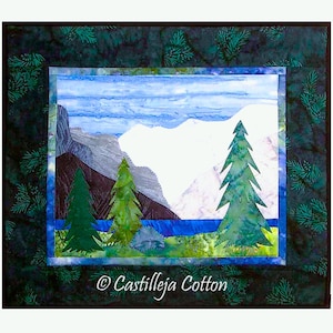 May include: A fabric art piece depicting a mountain landscape with evergreen trees, a blue lake, and a cloudy sky. The artwork is framed with a dark green border with a pine needle pattern. The text "© Castilleja Cotton" is in the lower right corner.