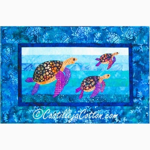 Peut inclure: Une courtepointe colorée représentant trois tortues marines nageant dans un océan bleu. Les tortues sont faites de tissu avec un motif de patchwork et ont des nageoires violettes. La courtepointe est bordée d'un tissu bleu avec un motif de tortues marines.