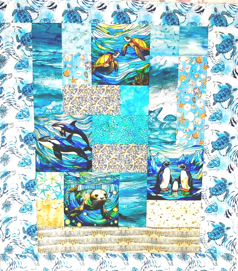 May include: A patchwork quilt featuring marine life scenes. The quilt showcases turtles, orcas, penguins, and a seal in vibrant blue, turquoise, and yellow hues. The border has a repeating pattern of turtles. The quilt is a square shape.