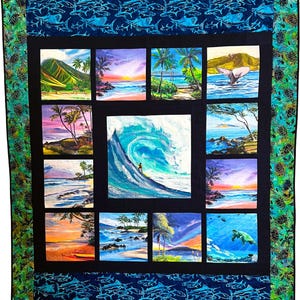 May include: A rectangular quilt featuring a central square panel of a surfer on a large wave, surrounded by twelve smaller square panels depicting tropical beach scenes, sunsets, and sea life, framed by a dark border and patterned fabric edges.