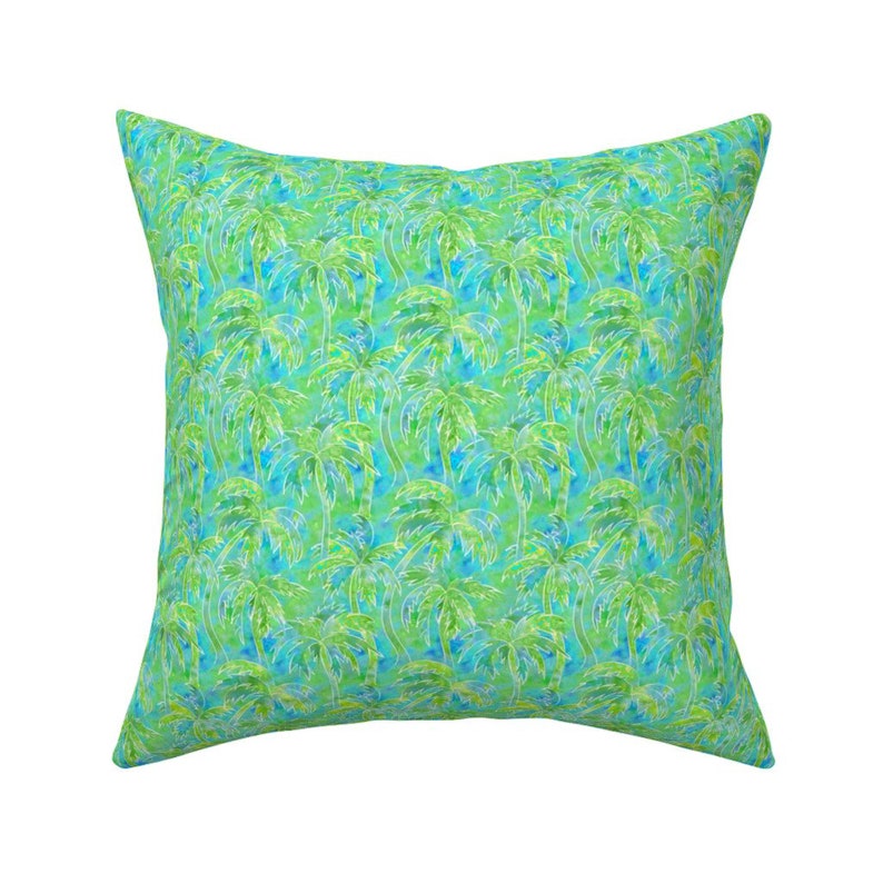 May include: A square throw pillow with a green and blue tropical palm tree pattern.