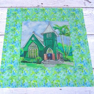 May include: A watercolor painting of a green church with a tall steeple and a palm tree in front. The church is surrounded by lush green foliage and a blue sky with white clouds. The painting is framed with a border of green and blue palm leaves.