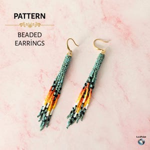 Peut inclure: Une paire de boucles d'oreilles perlées avec un haut turquoise et une frange colorée. La frange comprend des perles noires, orange, jaunes et blanches. Les boucles d'oreilles ont des crochets dorés et le texte "PATTERN BEADED EARRINGS".