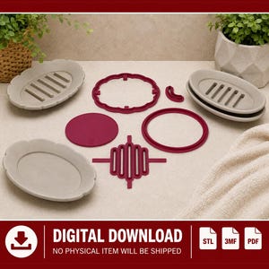 Può includere: Una collezione di componenti stampati in 3D per portasapone, che include tre vassoi ovali grigio chiaro con fessure di drenaggio, un inserto circolare rosso scuro, una cornice smerlata rosso scuro, un anello e un inserto a listelli.