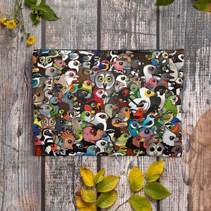 May include: A rectangular clutch featuring a vibrant, colorful pattern of various bird illustrations. The birds are depicted in a variety of colors, including blue, green, red, and yellow, against a black background. The clutch is made of a durable material.