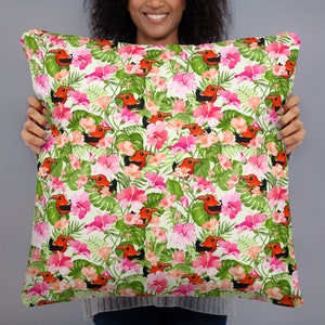 May include: A white throw pillow with a tropical print featuring red and black birds, pink flowers, and green leaves.