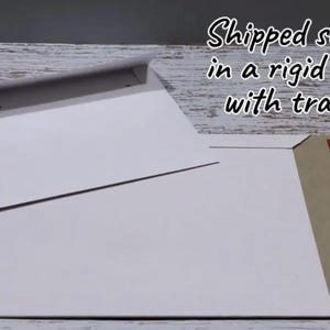 May include: Two white paper mailers, one smaller envelope with a flap and one larger rectangular rigid mailer featuring a brown cardboard edge and a red adhesive strip for sealing, presented as flat stationery supplies for mailing documents.
