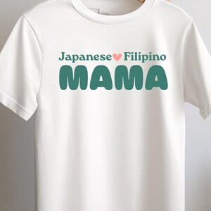 Könnte beinhalten: Weißes T-Shirt mit dem Text "Japanese ♥ Filipino MAMA" in grünen Buchstaben.