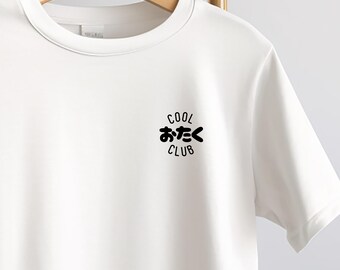 May include: White t-shirt with a crew neck, hanging on a wooden hanger. The shirt features the text "COOL おたく CLUB" in black, a Japanese-English phrase. The design is centered on the chest.