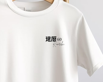May include: White t-shirt with the Japanese characters and the number 60, with the word "Kanreki" in a script font. The shirt is hanging on a wooden hanger.