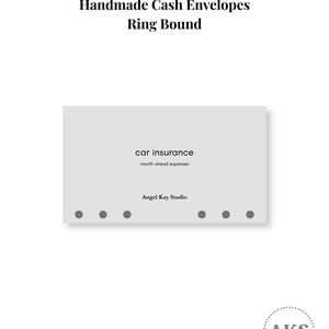 May include: A light gray rectangular cash envelope with six punched holes along the bottom edge. The text reads "car insurance", "month ahead expenses", and "Angel Kay Studio". The header text above the envelope reads "Handmade Cash Envelopes Ring Bound".