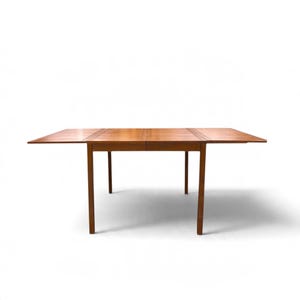 May include: A rectangular wooden dining table with a warm brown finish and a smooth surface. The table features four straight legs and two extendable side leaves that are currently pulled out to increase the total surface area.