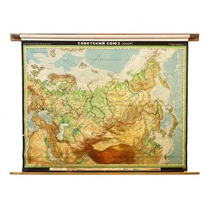 May include: A vintage, rolled-up map of the Soviet Union (USSR) with a wooden dowel at the top and bottom. The map is titled "Soviet Union (USSR)" and shows the terrain of the country in green, brown, and blue colors.