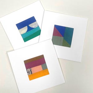Könnte beinhalten: Drei quadratische Kunstdrucke mit abstrakten geometrischen Designs. Jeder Druck zeigt eine farbenfrohe, geschichtete Komposition in Blau-, Grün-, Rosa- und Orangetönen. Die Drucke sind vor einem weißen Hintergrund platziert.