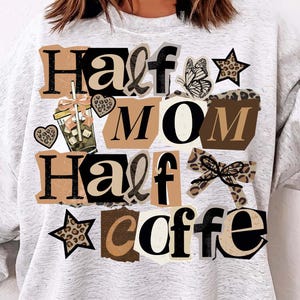 May include: A light gray sweatshirt with the text "Half Mom Half Coffee" in a collage style. The design includes a coffee cup, stars, a butterfly, and a bow with a leopard print pattern. The sweatshirt is a casual style.