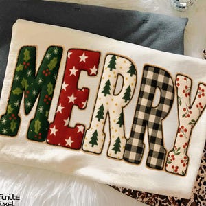 Könnte beinhalten: Ein cremefarbenes Sweatshirt zum Thema Weihnachten mit dem Wort "MERRY" in großen, dekorativen Buchstaben. Jeder Buchstabe hat ein anderes festliches Muster: Stechpalme, Sterne, Weihnachtsbäume, Büffelkaros und Beeren. Das Sweatshirt liegt auf einer weißen, flauschigen Oberfläche.