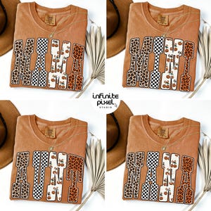 Puede incluir: Cuatro imágenes de una camiseta naranja quemado con la palabra "MAMA" en una mezcla de estampados de leopardo, cuadros y calabazas. La camiseta tiene cuello redondo y un collar dorado. El texto "infinite pixel studio" está en la esquina inferior derecha.