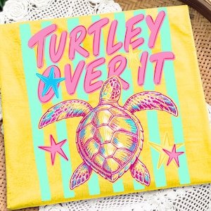 May include: A square canvas print with a yellow background and vertical light blue stripes. The print features a colorful sea turtle illustration and the text "Turtley Over It" in pink. Pink and blue star accents are also included.