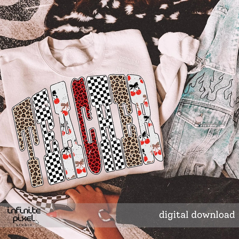 May include: A cream-colored sweatshirt with the word "TEACHER" in a bold, decorative font. The letters are filled with patterns like leopard print, checkered, and cherry designs. A denim jacket and checkered shoes are also visible.