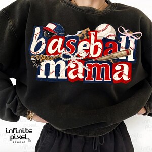 May include: Black sweatshirt with the words "Baseball Mama" in red, white, and blue lettering. The design includes a baseball, bat, and a baseball cap. A pearl necklace and a pink bow are also included in the design.