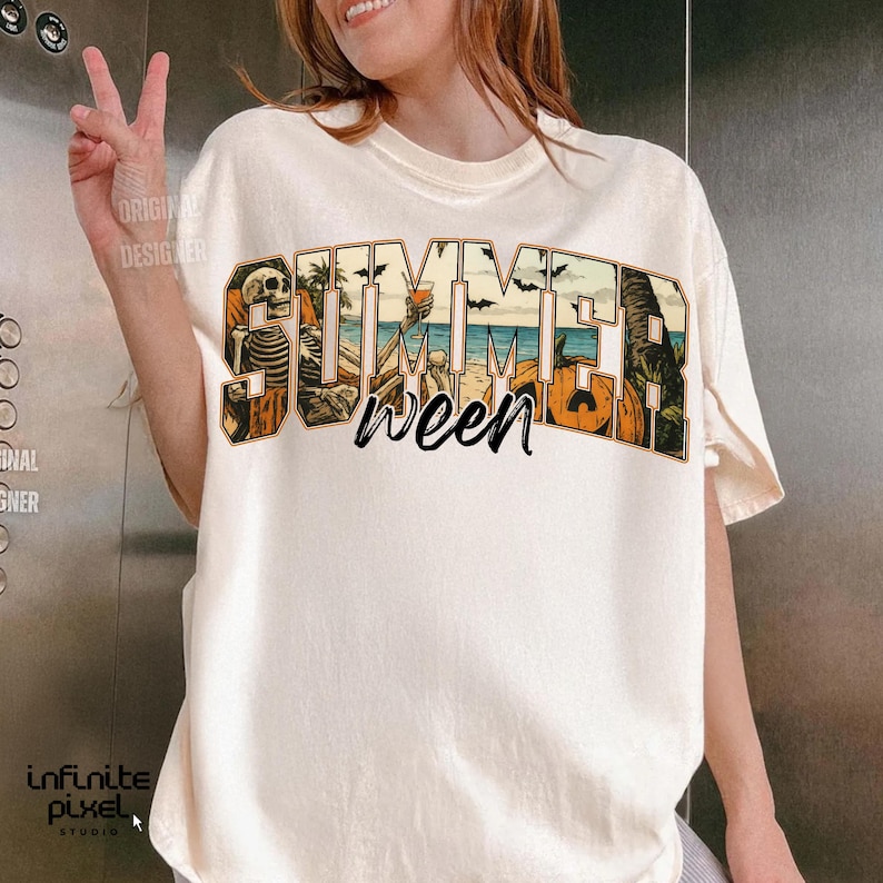 May include: Cream-colored t-shirt with a graphic that reads "Summerween." The design incorporates a skeleton, beach scene, palm trees, and pumpkins. The shirt has short sleeves and a relaxed fit.
