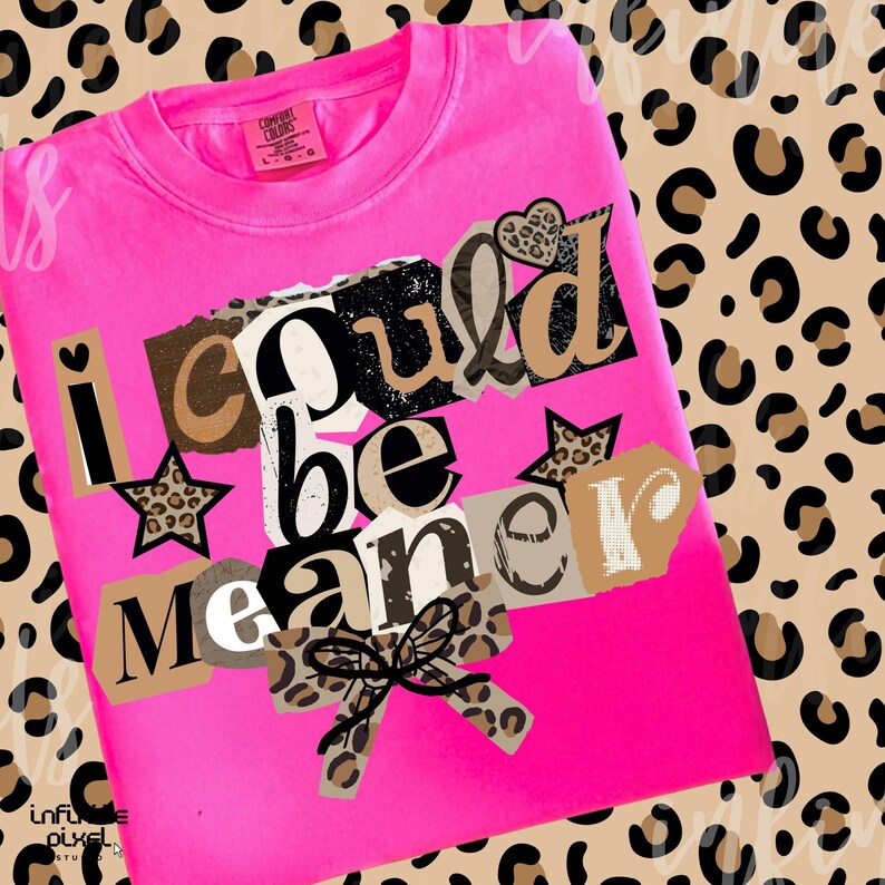 May include: A bright pink Comfort Colors sweatshirt with the phrase "I could be meaner" in a collage style. The design includes leopard print accents, stars, and a bow. The background features a leopard print pattern.