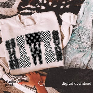 May include: A cream-colored sweatshirt with the word "HAWKS" in large, bold letters. The letters are a mix of patterns, including checkered, star-filled, and leopard print designs. A denim jacket with flame designs is visible.
