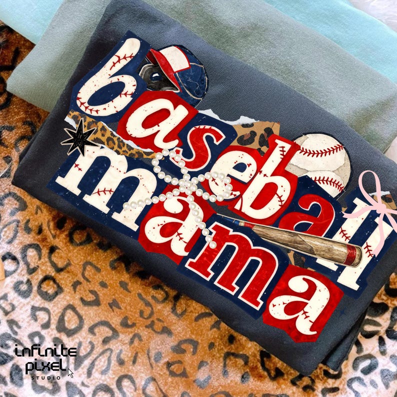 May include: A dark gray t-shirt with the words "Baseball Mama" in red, white, and blue, with baseball-themed graphics. The design includes a baseball, bat, and a baseball cap. The shirt is folded on a leopard print surface.