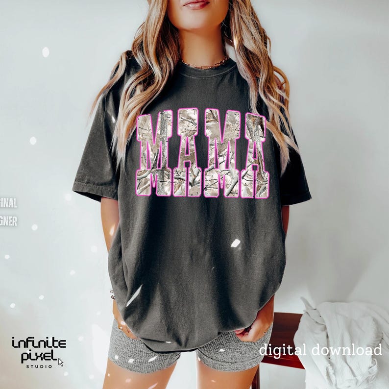 May include: Dark gray t-shirt with the word "MAMA" in a camouflage design with pink outlines. The shirt is a relaxed fit and has short sleeves. The image also includes the text "digital download".
