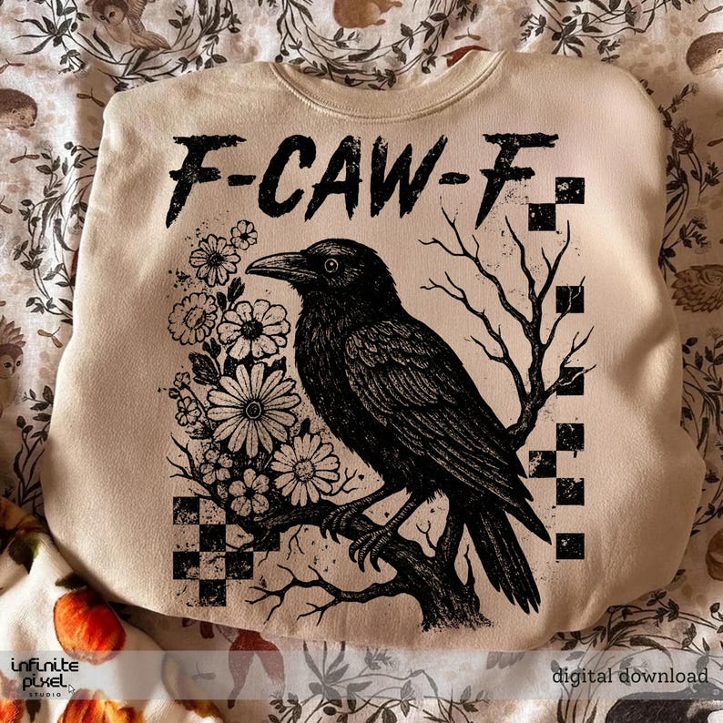 Puede incluir: Sudadera beige con una ilustraci&oacute;n de un cuervo negro posado en una rama, rodeado de flores y un &aacute;rbol. El texto "F-CAW-F" est&aacute; impreso en la parte superior. El dise&ntilde;o es una descarga digital.