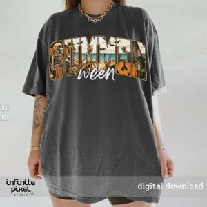 May include: Dark gray t-shirt with a graphic that says "Summerween" in a stylized font. The design incorporates a skeleton, palm trees, pumpkins, and a beach scene, blending summer and Halloween themes.