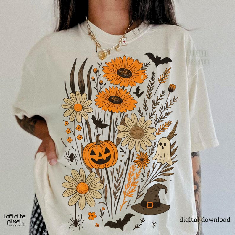 Peut inclure: T-shirt cr&egrave;me avec un motif floral sur le th&egrave;me d'Halloween. Le graphisme comprend des tournesols orange, des marguerites, une citrouille-lanterne, des chauves-souris, un fant&ocirc;me et un chapeau de sorci&egrave;re. Les mots "t&eacute;l&eacute;chargement num&eacute;rique" et "designer original" sont imprim&eacute;s.