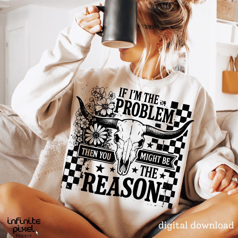 May include: Cream-colored sweatshirt with a graphic design featuring a bull skull, flowers, and the text "IF I'M THE PROBLEM THEN YOU MIGHT BE THE REASON." The design is in black and white.