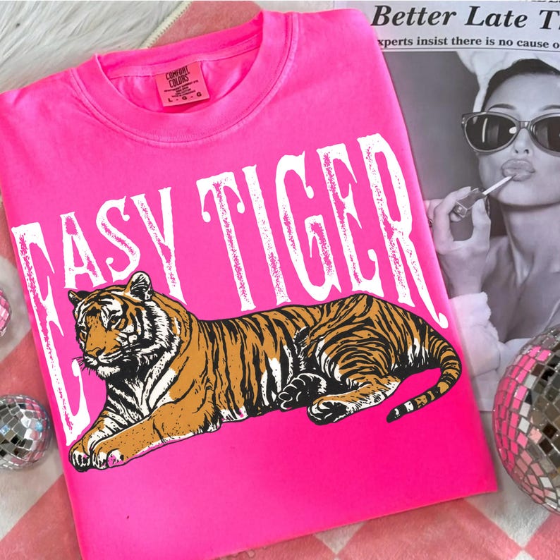 May include: Bright pink Easy Tiger t-shirt with a tiger graphic. The text "EASY TIGER" is in white block letters above the tiger. The tiger is orange and black. The shirt is a Comfort Colors brand.
