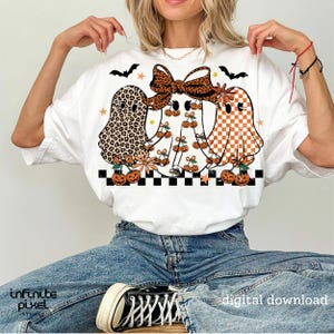 May include: White t-shirt featuring three ghost illustrations with various patterns, including leopard print, cherries, and orange checkered designs. The ghosts are decorated with bows, flowers, and pumpkins. The text "digital download" is visible.