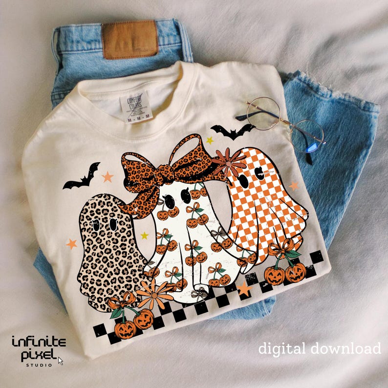 May include: Cream-colored t-shirt featuring three ghost characters with unique patterns and designs. The ghosts have leopard print, checkered, and cherry patterns. The shirt includes bats, stars, and pumpkins, with the text "digital download".