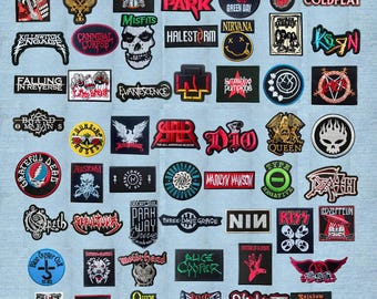 May include: A collection of embroidered fabric patches featuring various band logos and music-related graphics, including names like Metallica, Nirvana, Queen, Slipknot, and Green Day, arranged in a grid pattern on a light blue denim background.