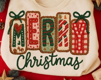 May include: Cream-colored sweatshirt with the words "MERRY CHRISTMAS" in a festive design. The letters are in a gingerbread-style font, with red, green, and white patterns. A green bow adorns the top of each letter. The sweatshirt is on a red background.