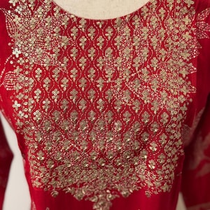 May include: Red kurta with gold embroidery and sequins. The embroidery features a floral pattern.