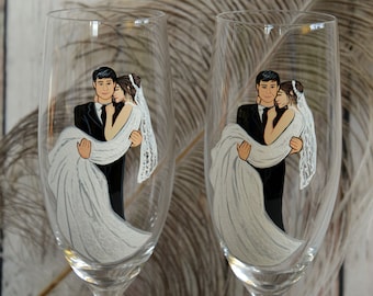 May include: Two champagne flutes with painted designs of a bride and groom. The bride is wearing a white dress and the groom is wearing a black suit. The couple are holding each other and smiling.