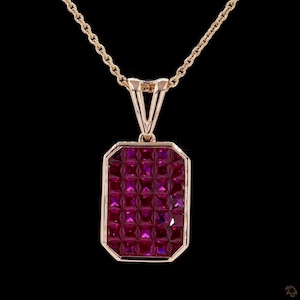 Può includere: Collana dorata con pendente rettangolare. Il pendente è riempito di piccole pietre preziose rosa scuro a taglio quadrato. La catena e l'incastonatura del pendente sono dorate, creando un aspetto lussuoso su sfondo nero. Gioiello.