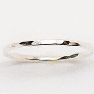 May include: A simple silver band ring with a hammered finish.