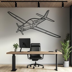 May include: A black metal wall art piece shaped like a single-engine propeller airplane. The design features a minimalist outline of the aircraft, including the wings, fuselage, cockpit window, tail section, and a three-bladed propeller at the front.