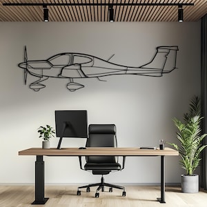 Könnte beinhalten: Ein schwarzes Wandkunstobjekt aus Metall in Form eines einmotorigen Flugzeugs im Profil. Das Design besteht aus einer minimalistischen Drahtgitter-Kontur des Flugzeugs, einschließlich Propeller, Cockpitfenstern, Flügeln, Fahrwerk und Heck.