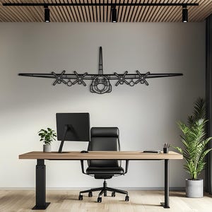 May include: A black metal wall art piece shaped like a four-engine propeller aeroplane. The silhouette features a central fuselage, long wings, and four distinct propeller engines. The design is constructed from thin, dark metal lines.