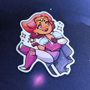 Pode incluir: Um adesivo com um personagem de desenho animado com cabelo rosa e uma roupa rosa e roxa. O personagem est&aacute; sorrindo e tem uma express&atilde;o determinada. O adesivo tem uma borda branca e est&aacute; em um fundo azul escuro.